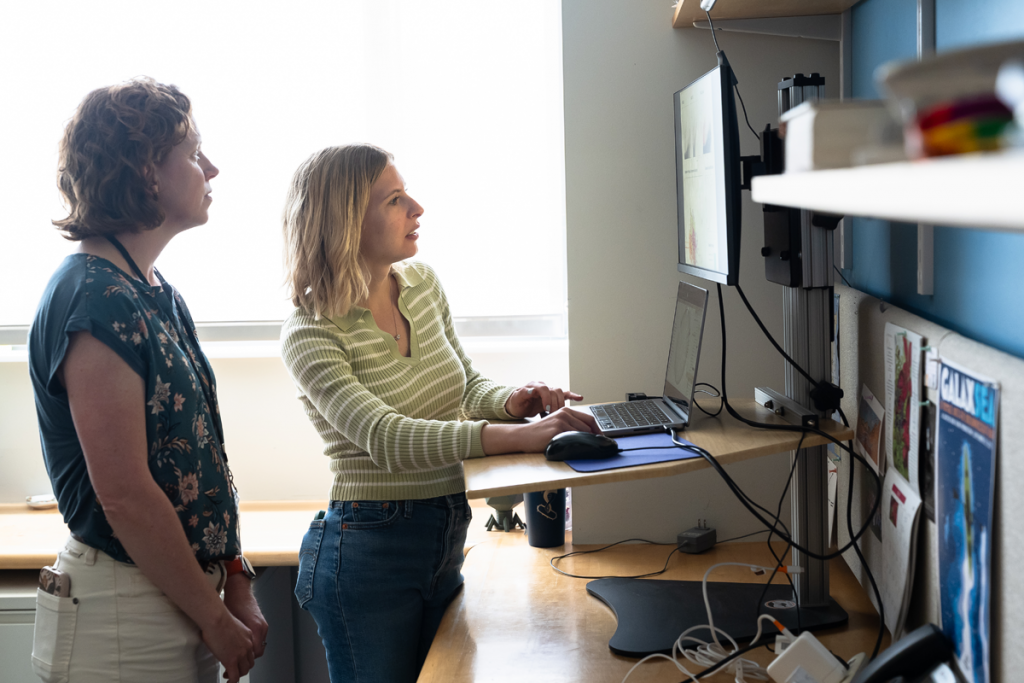 Julia Brown, senior research scientist and co-director of the Single Cell Genomics Center, listens as Alaina Weinheimer, postdoctoral researcher, explains a visualization.